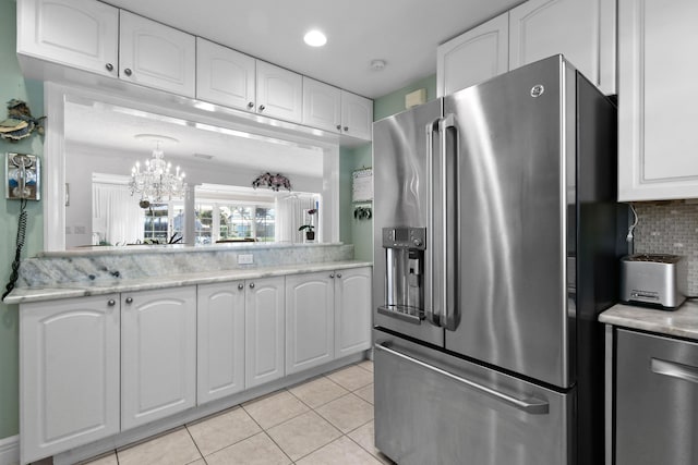 kitchen with backsplash, high end refrigerator, white cabinets, and light tile patterned flooring