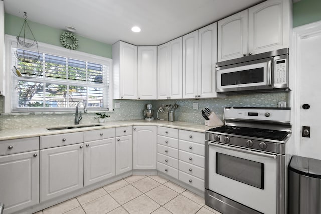 kitchen with white cabinetry, sink, gas range, and decorative backsplash