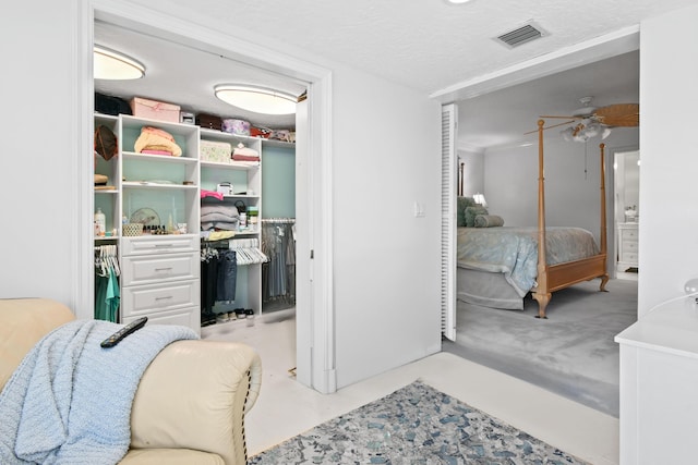 bedroom featuring a walk in closet, a closet, and a textured ceiling