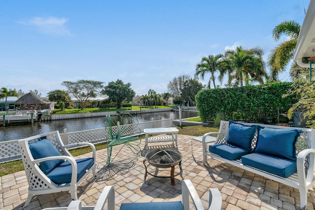 view of patio / terrace featuring an outdoor living space with a fire pit and a water view