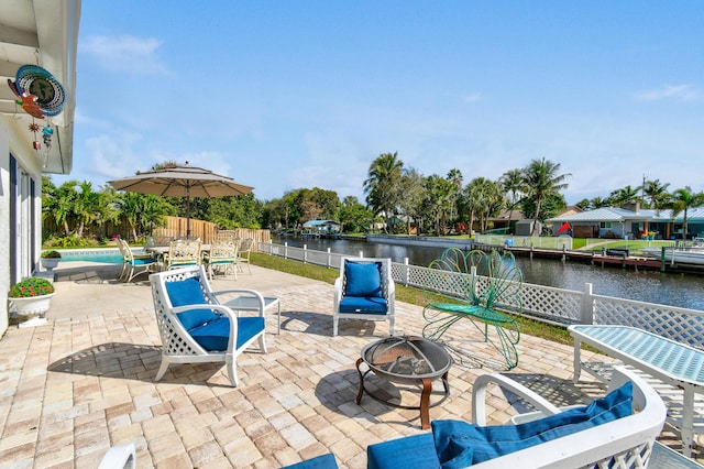 view of patio with a water view and an outdoor fire pit