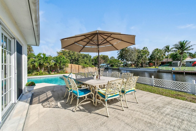 view of patio / terrace with a fenced in pool and a water view