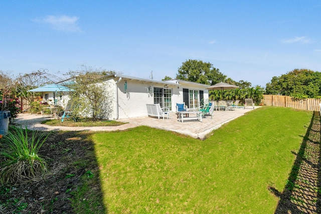 rear view of property featuring a patio and a yard