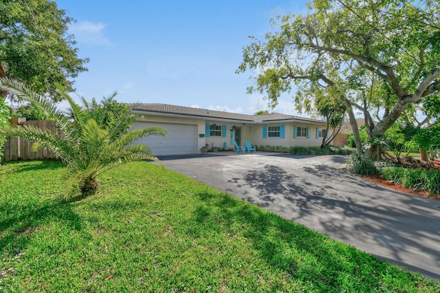 ranch-style house featuring a garage and a front yard