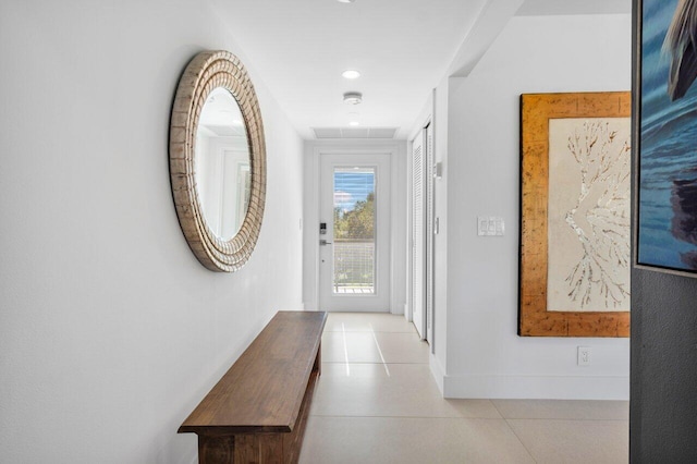 hall featuring baseboards and light tile patterned floors