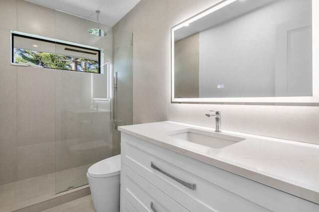 bathroom with vanity, toilet, decorative backsplash, and a tile shower