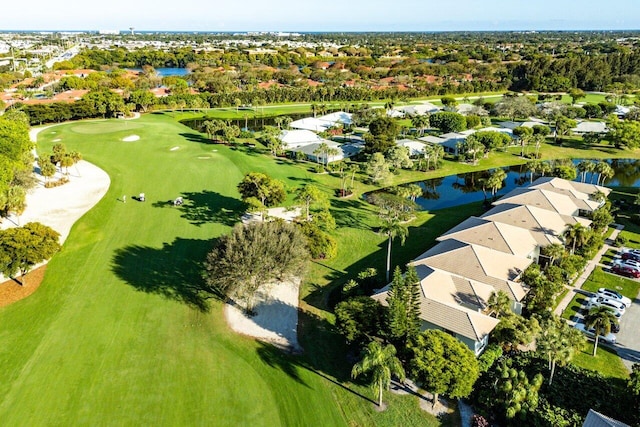 birds eye view of property with view of golf course and a water view