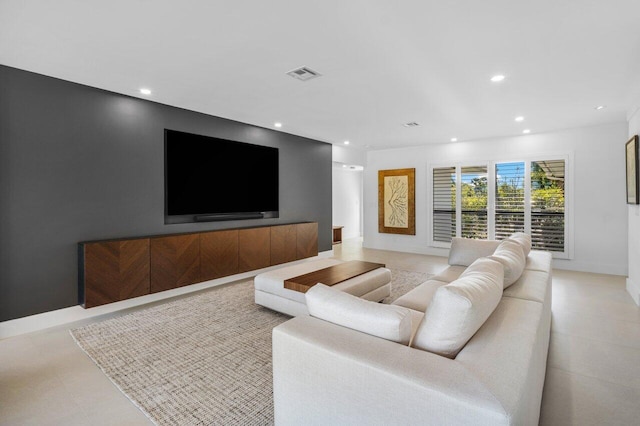 living room featuring baseboards, visible vents, and recessed lighting