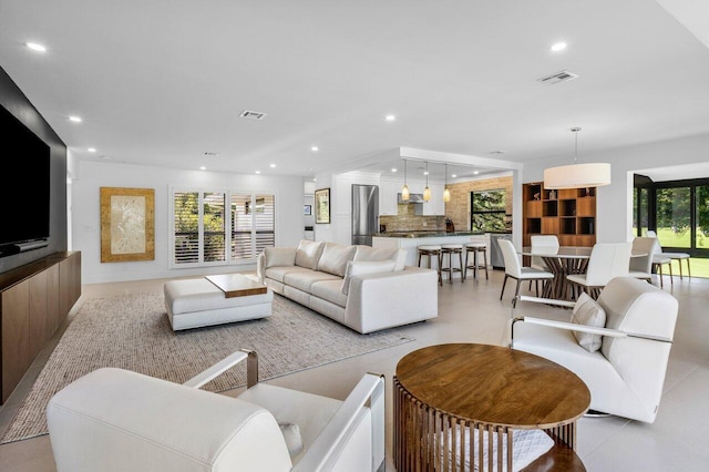 living area with recessed lighting, visible vents, and light tile patterned floors