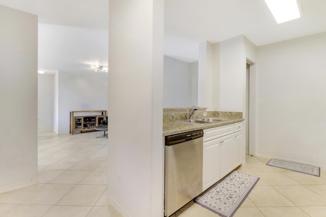 kitchen with sink, stainless steel dishwasher, white cabinets, and light tile patterned floors