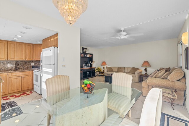 kitchen featuring tasteful backsplash, sink, light tile patterned floors, light stone counters, and white appliances