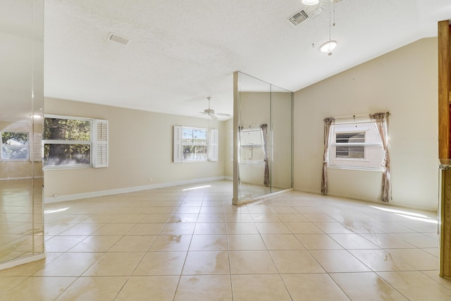 spare room with lofted ceiling, light tile patterned floors, and ceiling fan