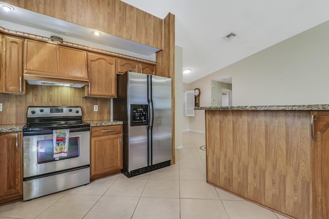 kitchen with light stone countertops, stainless steel appliances, custom range hood, and light tile patterned flooring