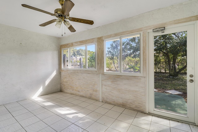 unfurnished sunroom featuring ceiling fan