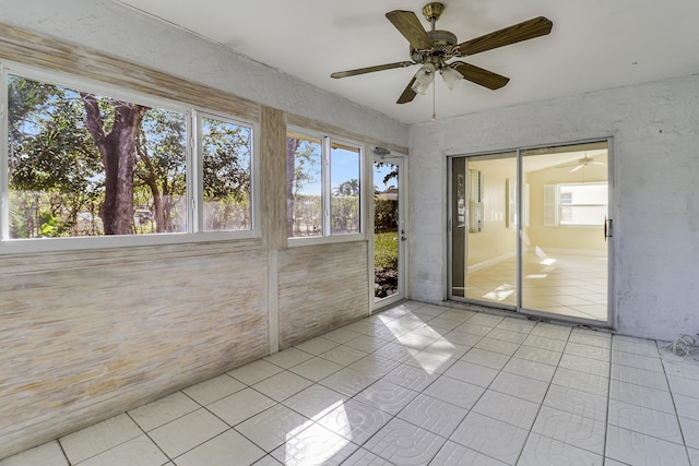 unfurnished sunroom with ceiling fan