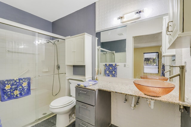 bathroom with toilet, an enclosed shower, and sink