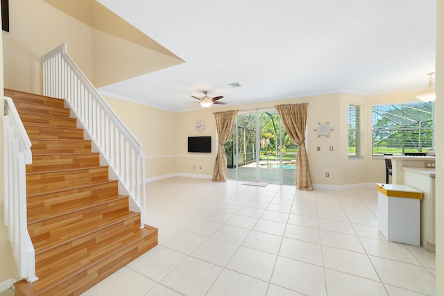 unfurnished living room featuring crown molding, ceiling fan, and light tile patterned flooring