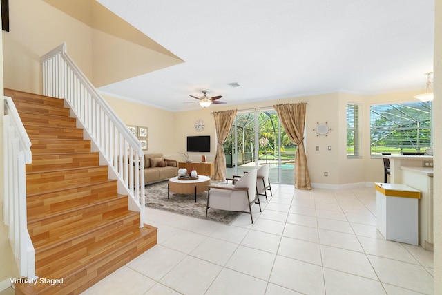 living room featuring light tile patterned flooring, ceiling fan, and crown molding