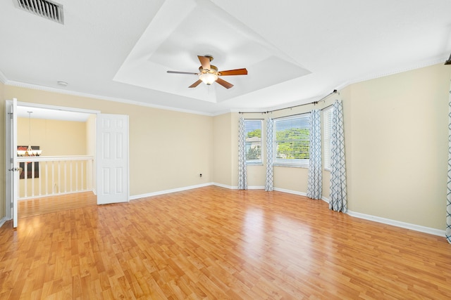 spare room featuring wood-type flooring, crown molding, ceiling fan, and a tray ceiling