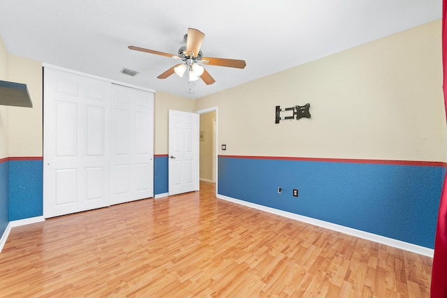 unfurnished bedroom featuring wood-type flooring, a closet, and ceiling fan