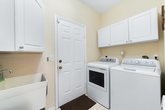 laundry room with independent washer and dryer, cabinets, and sink