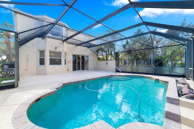 view of swimming pool featuring a lanai and a patio area