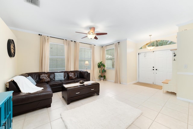 living room with crown molding, ceiling fan, and light tile patterned floors