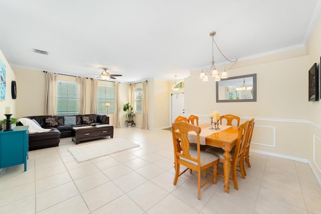 tiled dining space with crown molding and ceiling fan with notable chandelier