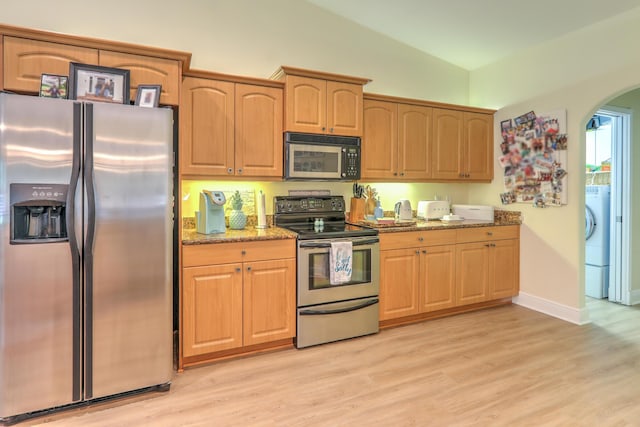 kitchen with light stone counters, lofted ceiling, stainless steel appliances, and light wood-type flooring