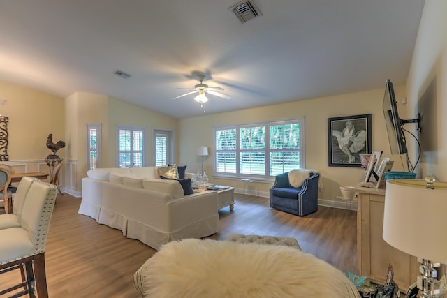 living room with lofted ceiling, hardwood / wood-style flooring, and ceiling fan