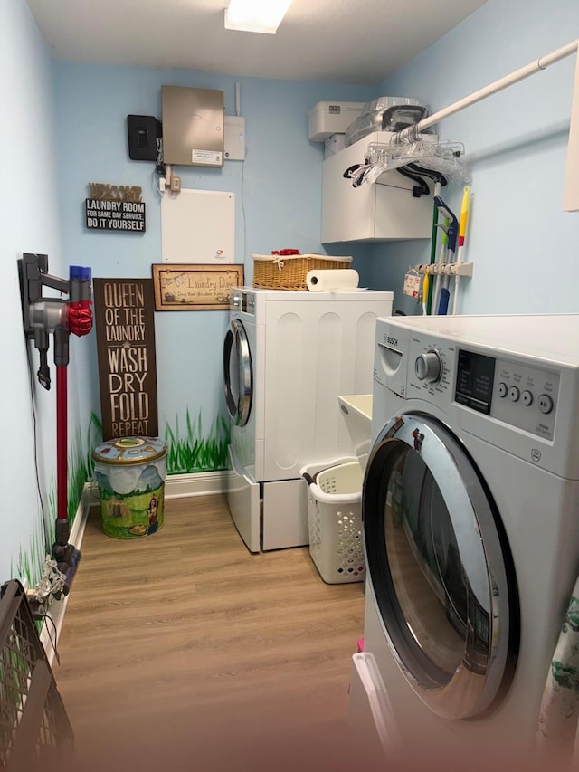 laundry area featuring washer and clothes dryer and light hardwood / wood-style flooring