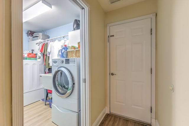 laundry area featuring washer / clothes dryer and light hardwood / wood-style flooring