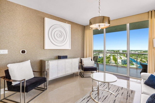 sitting room featuring a water view, light tile patterned flooring, and wallpapered walls