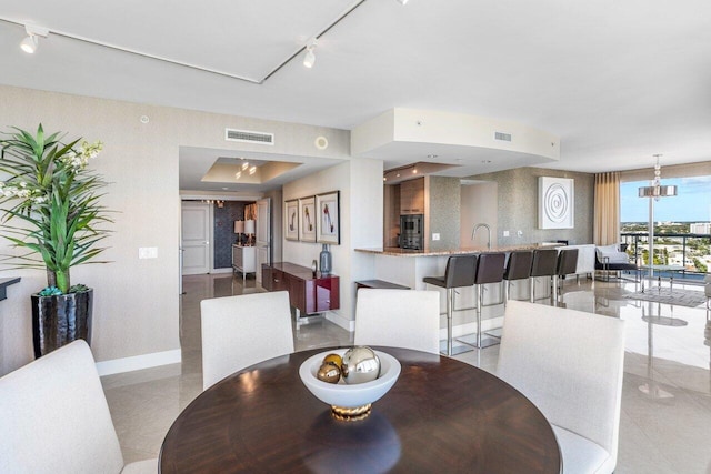 dining room featuring rail lighting, baseboards, and visible vents