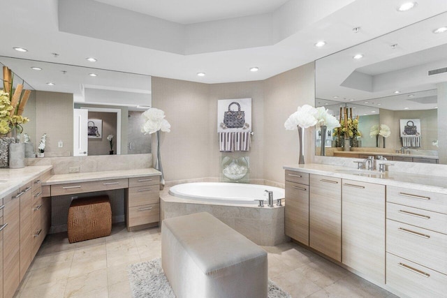 bathroom featuring recessed lighting, a raised ceiling, a bath, and vanity