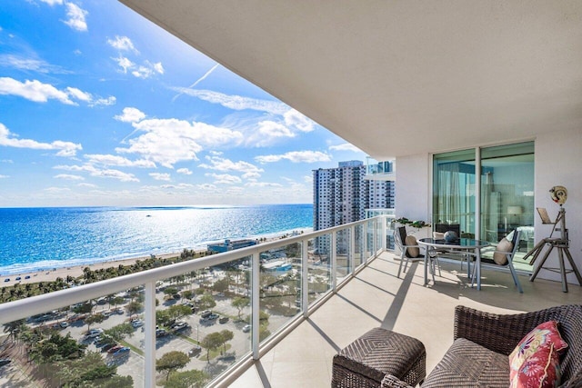 balcony featuring a water view and a view of the beach