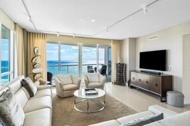 living room featuring a wall of windows, visible vents, and track lighting