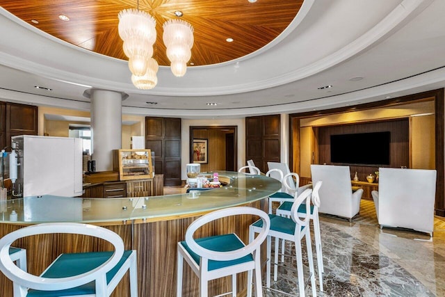 kitchen with a chandelier, wood ceiling, a raised ceiling, and marble finish floor