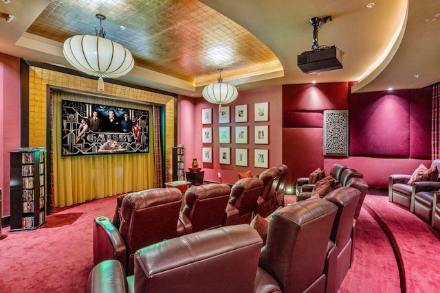 carpeted cinema room with a raised ceiling