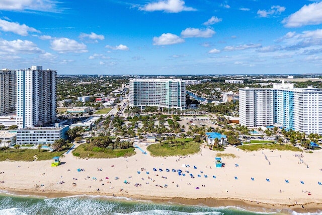 drone / aerial view with a water view, a beach view, and a city view