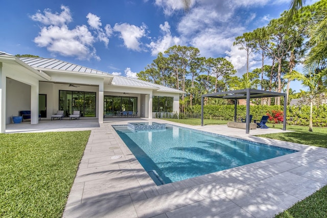 view of pool with a patio, ceiling fan, and a lawn