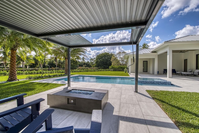 view of pool featuring a yard, a patio area, ceiling fan, and a fire pit