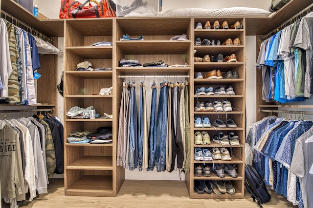 walk in closet with light hardwood / wood-style floors