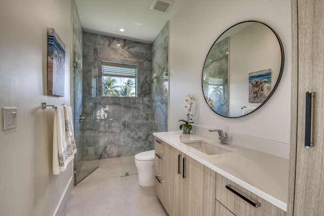 bathroom featuring tile patterned floors, vanity, toilet, and a shower with shower door