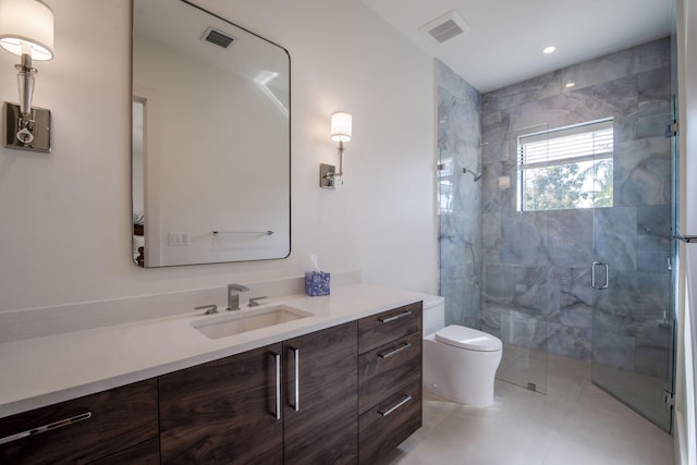 bathroom with vanity, toilet, a shower with shower door, and tile patterned flooring