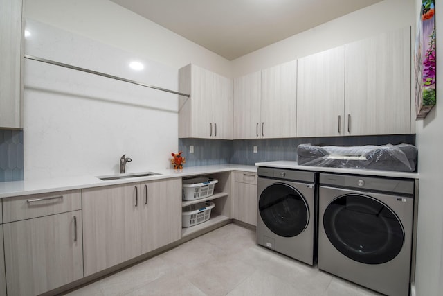 washroom featuring cabinets, sink, and washing machine and clothes dryer