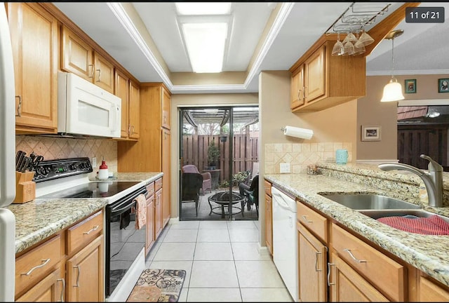 kitchen with light stone counters, sink, white appliances, and ornamental molding