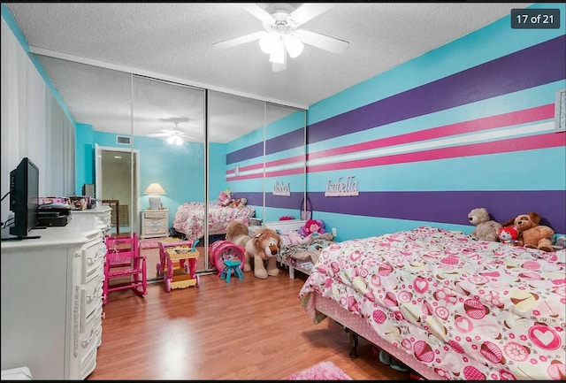 bedroom featuring hardwood / wood-style flooring, ceiling fan, and a textured ceiling