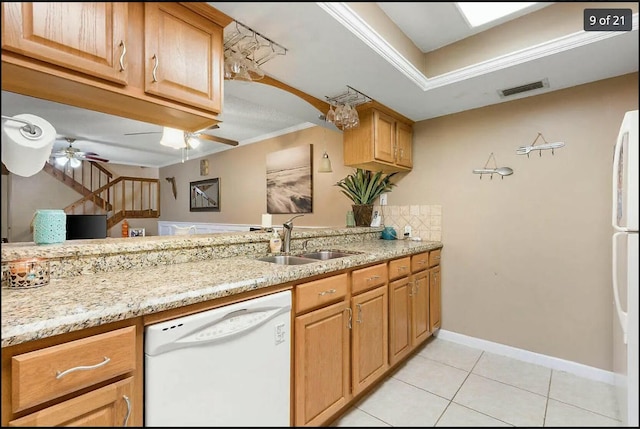 kitchen with dishwasher, sink, light tile patterned floors, ceiling fan, and light stone countertops