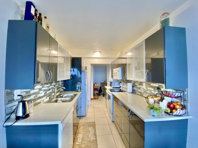 kitchen featuring sink, white appliances, backsplash, white cabinets, and light tile patterned flooring